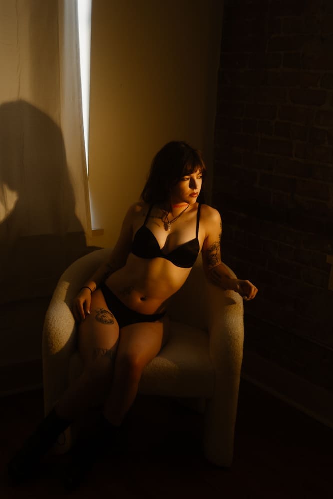 woman sitting in a chair during golden hour boudoir session at the lightfoot studio in knoxville