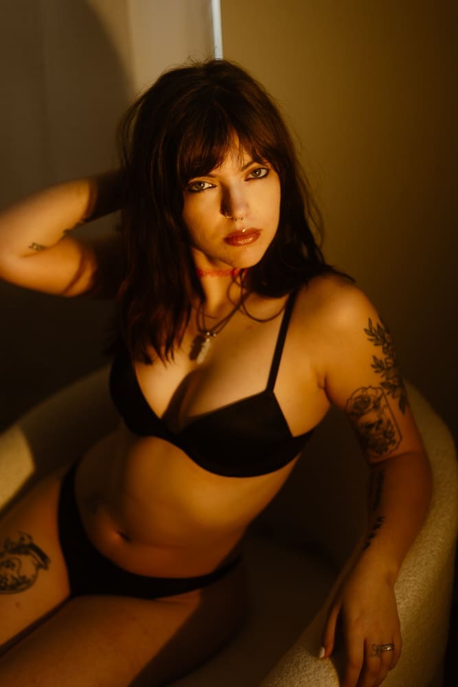 woman sitting in a chair during golden hour boudoir session at the lightfoot studio in knoxville