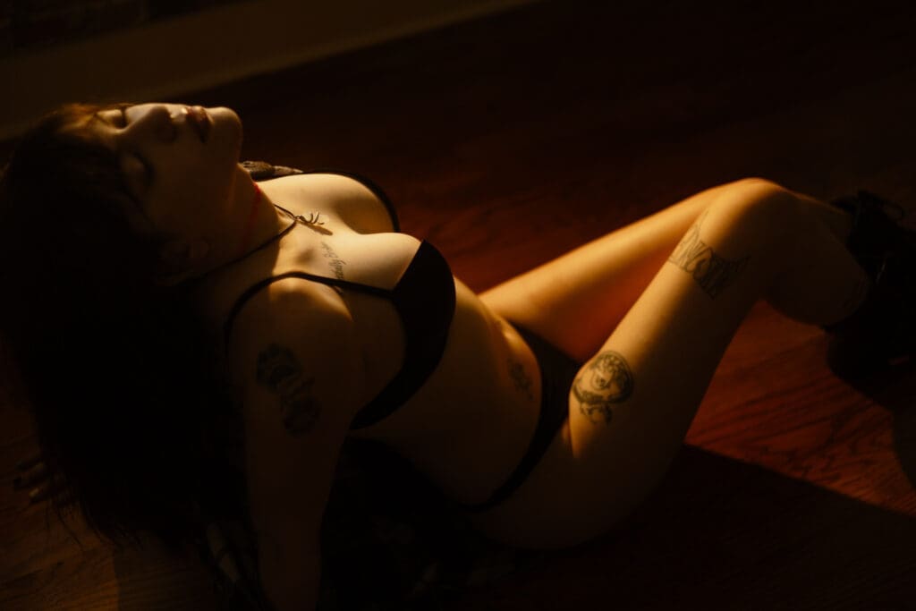 woman sitting on floor during golden hour boudoir session at the lightfoot studio in knoxville