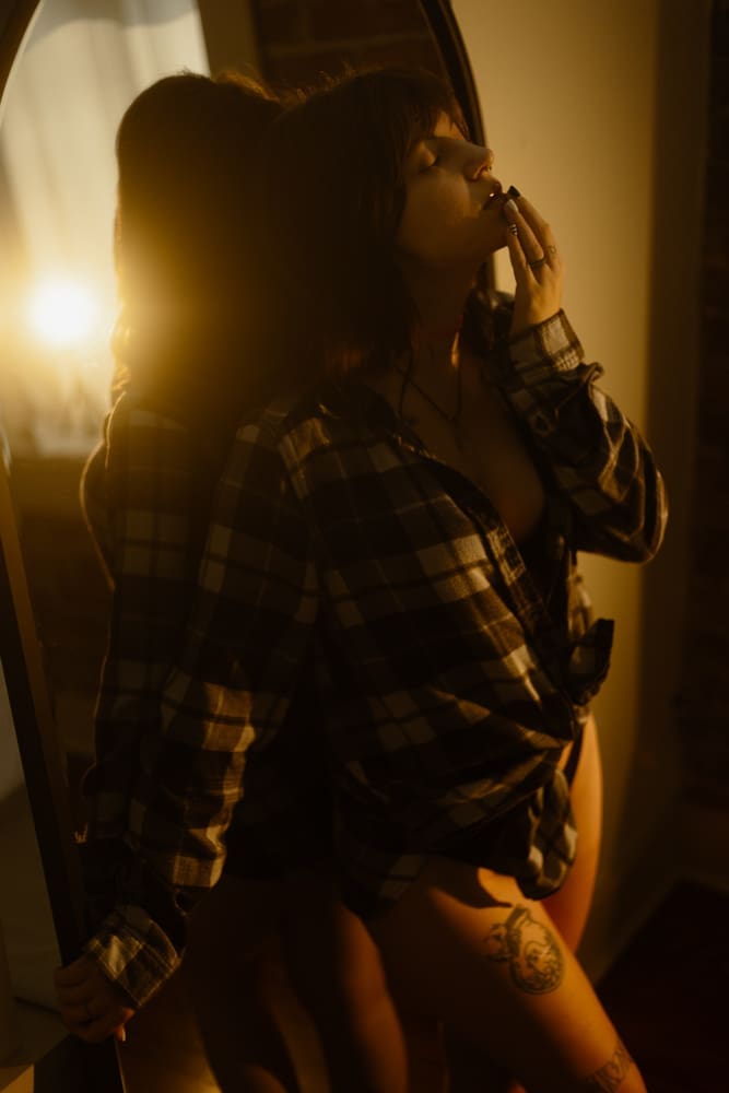 woman leaning against mirror during golden hour boudoir session at the lightfoot studio in knoxville