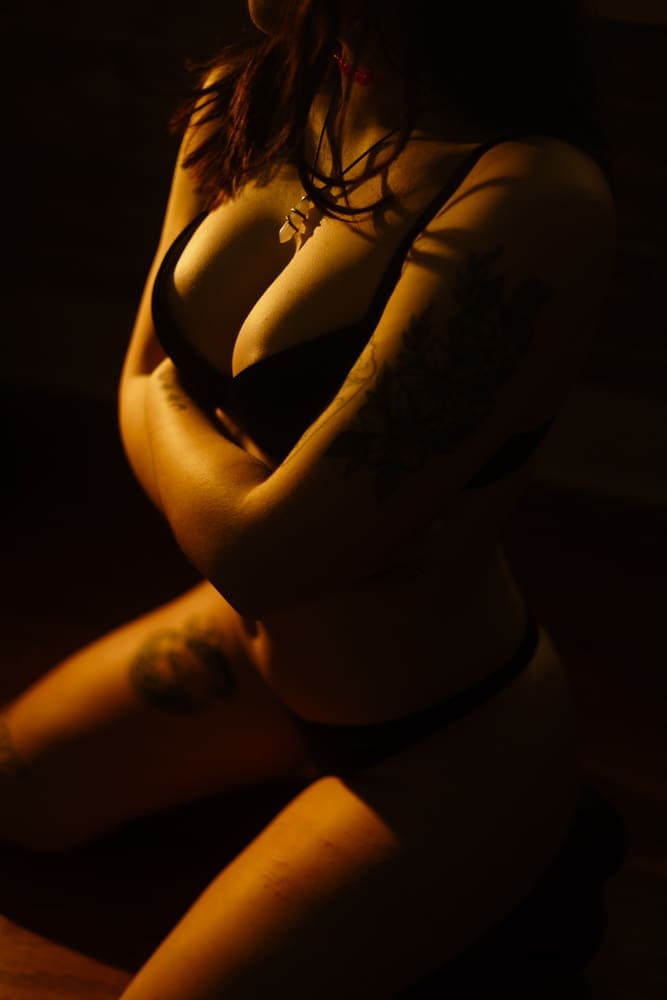woman kneeling on floor during golden hour boudoir session at the lightfoot studio in knoxville
